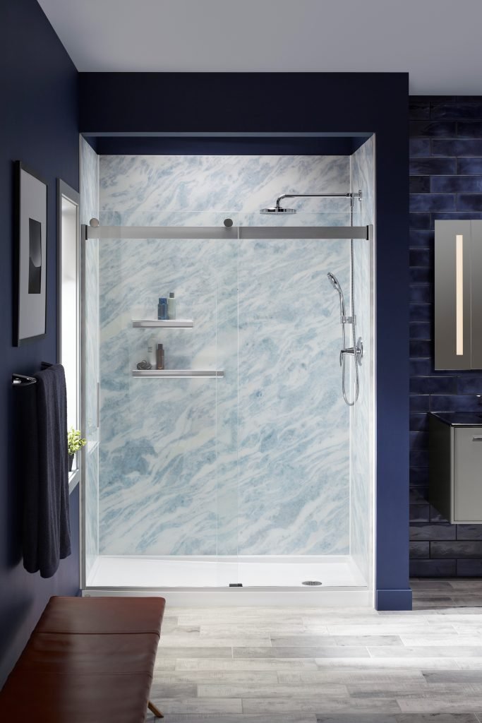 Marble walk-in shower with glass door and built-in shelf