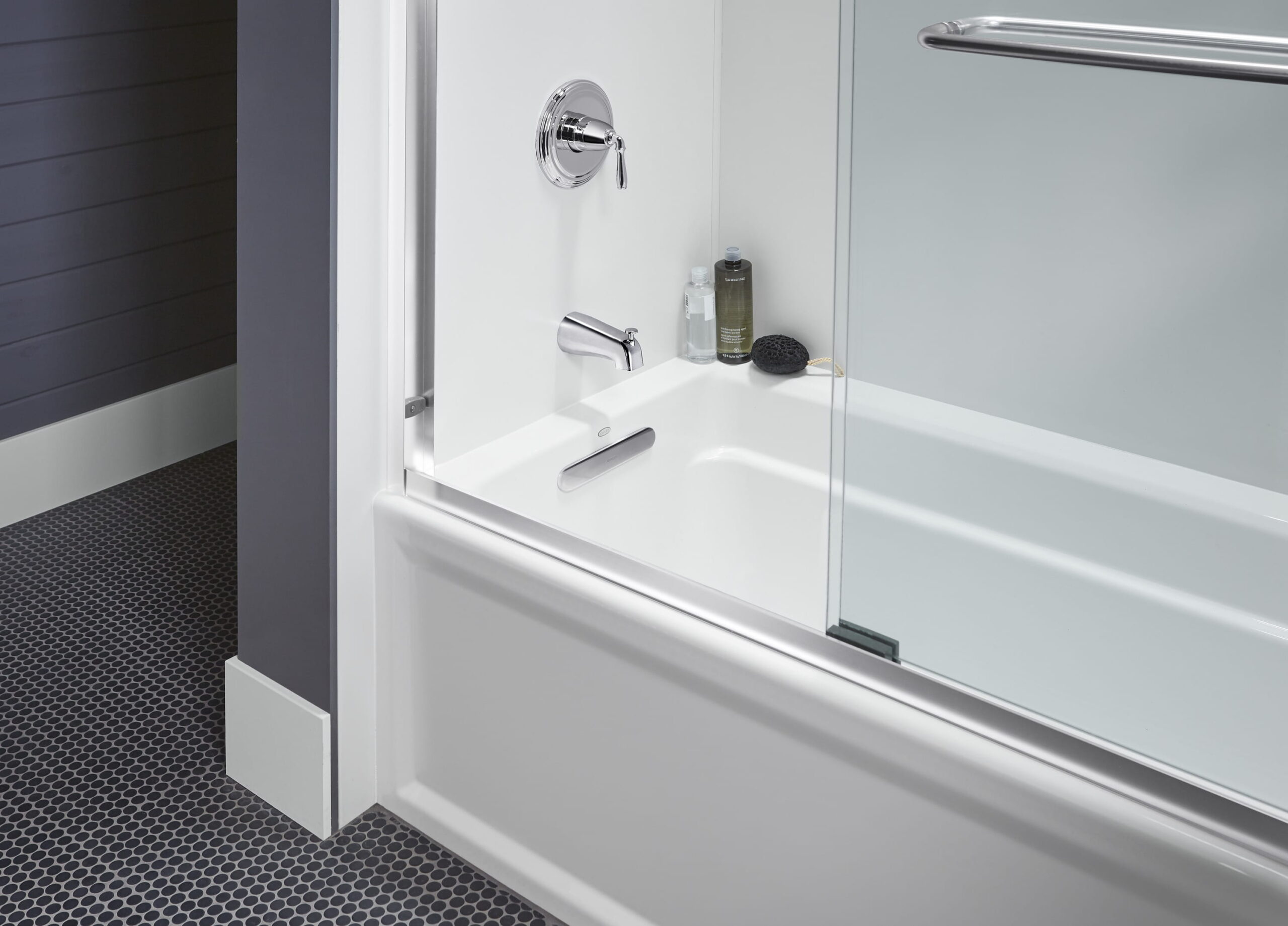 Glass bathtub door with chrome handle and clean white surround