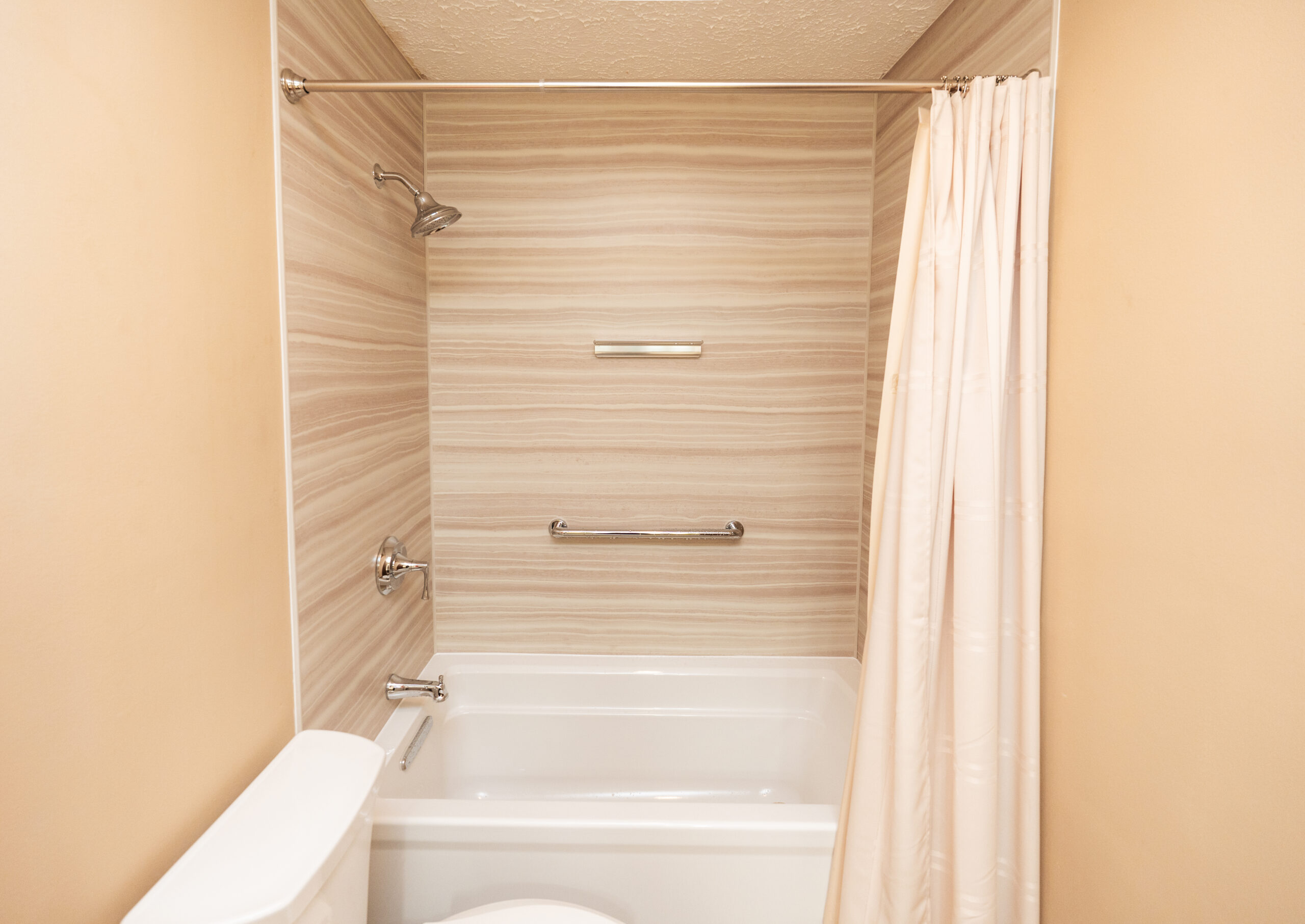 Walk-in shower with wood-look wall panels and built-in bench