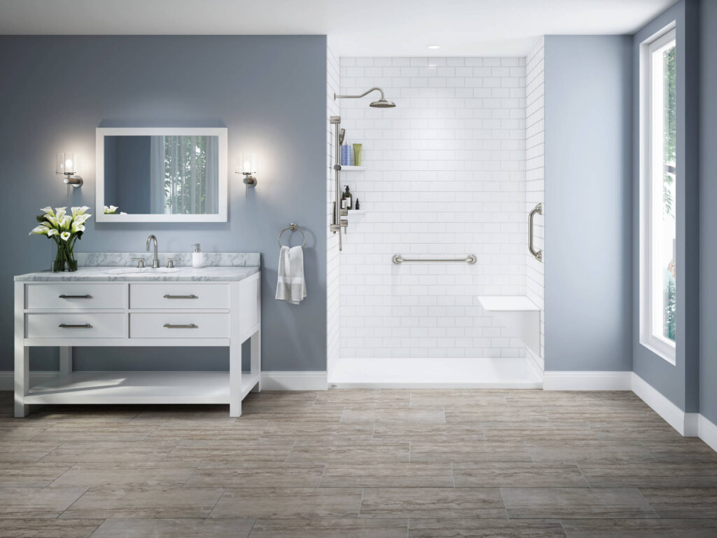 Walk-in shower with grab bars, built-in seat, and subway tile walls in bathroom with light blue walls and single-sink vanity