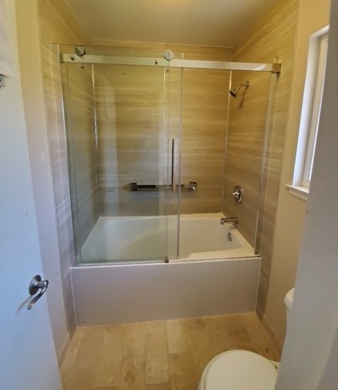 Bathtub and shower combination with glass sliding doors and tiled walls