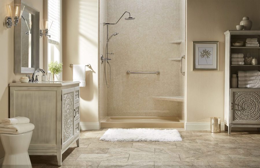 Walk-in shower with built-in seat, grab bars, and handheld showerhead in beige bathroom