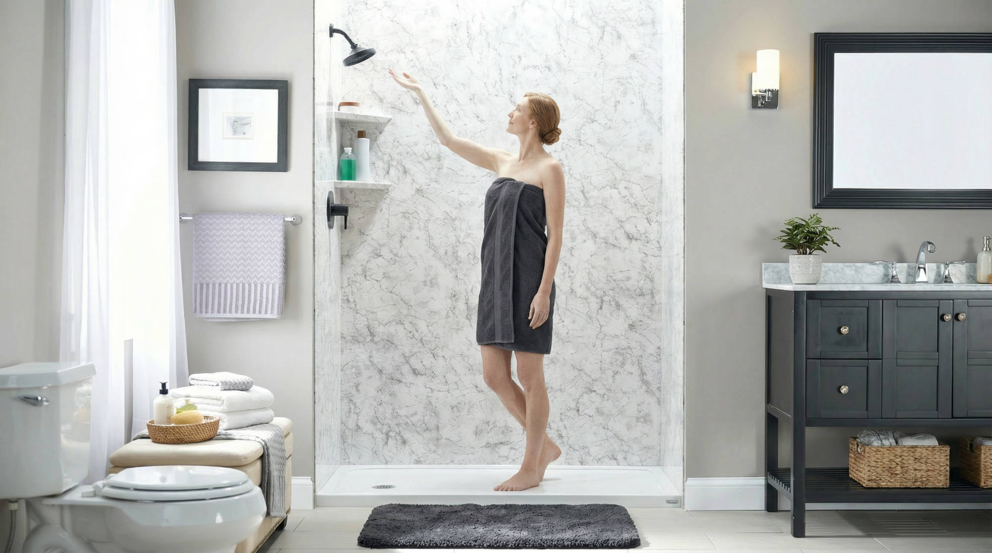 Woman standing in a walk-in shower adjusting the showerhead in a modern bathroom.