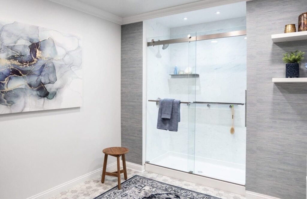Modern bathroom with frameless glass shower, sliding door, and tiled walls.