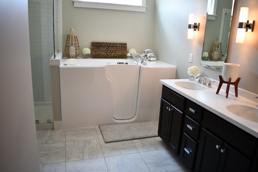 A bathroom featuring a white walk-in bathtub and double sink vanity.