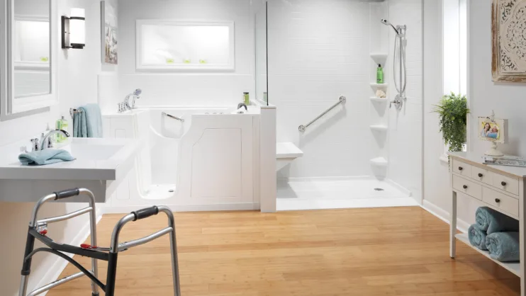 Accessible white bathroom with walk-in shower, grab bars, and walker
