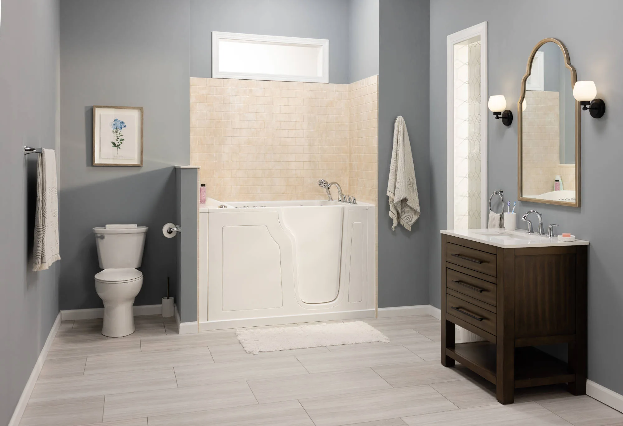 White walk-in bathtub with an outward-swinging door in a gray bathroom